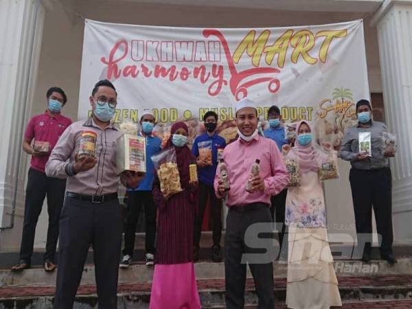 Mohd Farid dan kakitangannya menunjukkan produk yang dijual di Ukhwah Harmony Mart yang terletak di Pusat Niaga Bukit Baru Utama, Melaka.