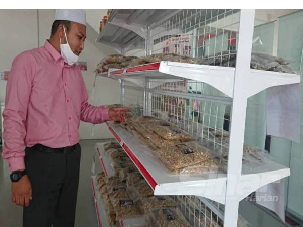 Mohd Farid menunjukkan produk Ikan Bilis Pangkor yang dijual di Ukhwah Harmony Mart.