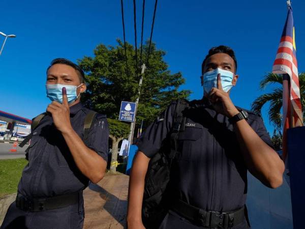 Anggota Polis menunjukkan jari berdakwat selepas selesai mengundi awal pada Pilihan Raya Kecil (PRK) Dewan Undangan Negeri (DUN) Slim di Ibu Pejabat Polis Daerah Muallim hari ini.
