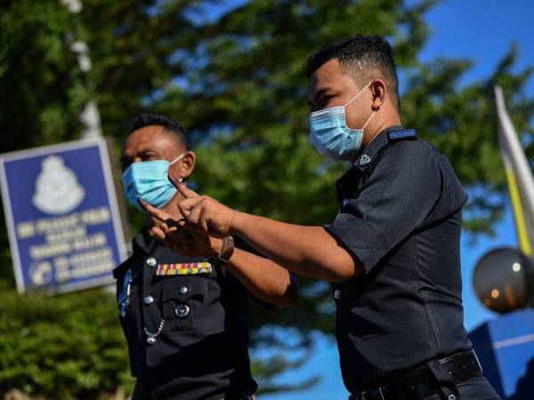  Anggota Polis menunjukkan jari berdakwat selepas selesai mengundi awal pada Pilihan Raya Kecil (PRK) Dewan Undangan Negeri (DUN) Slim di Ibu Pejabat Polis Daerah Muallim hari ini.