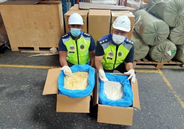 Dua pegawai Maqis Pulau Pinang menunjukkan serbuk kuning dan putih telur yang dirampas.