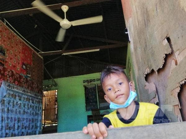 Kanak-kanak orang asli di Kampung Sungai Teras menunjukkan rumahnya yang sudah dipasang kipas.