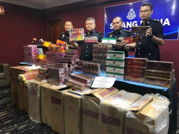 Ab Rashid (dua dari kiri) bersama barisan pegawai menunjukkan rokok seludup dan mercun yang dirampas pasukan polis dari sebuah rumah milik peniaga kedai runcit di Wakaf Bharu, Tumpat.