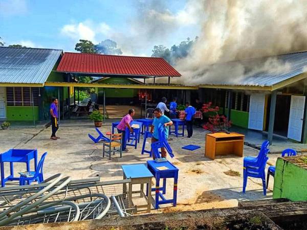 Pengajar dan pelajar menyelamatkan peralatan sekolah dalam kebakaran.