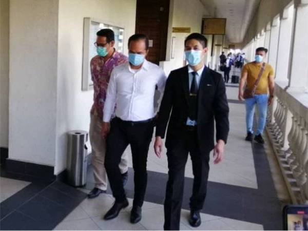 Muhammad Saiful (depan, kiri) ketika hadir di Mahkamah Sesyen Kuala Lumpur hari ini.