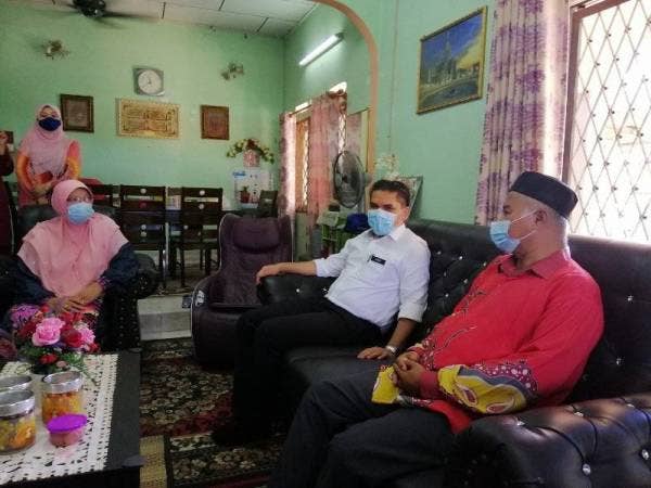 Dr Mohd Radzi (tengah) mengadakan kunjungan ke kediaman pasangan pesara guru, Che Rosnah Zainol, 60, dan Mohd Nadzri Mohd Nadzir, 62, di Taman Bandar Baru, Slim River hari ini.