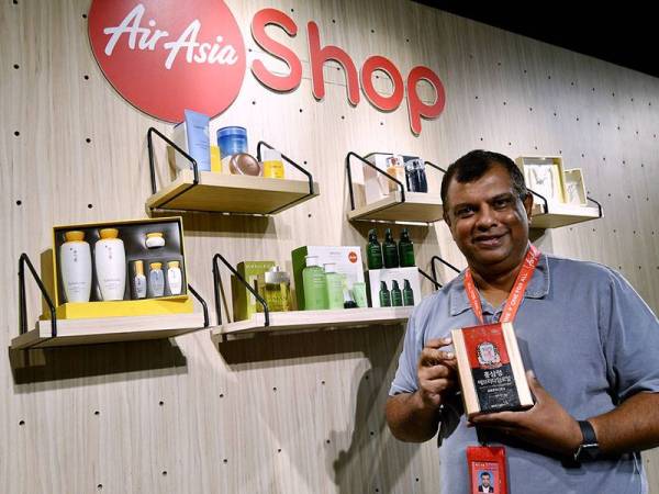 Ketua Pegawai Eksekutif Kumpulan AirAsia Tan Sri Tony Fernandes menunjukkan antara barangan yang dijual di Airasia Shop selepas majlis pelancarannya di KL Sentral hari ini.