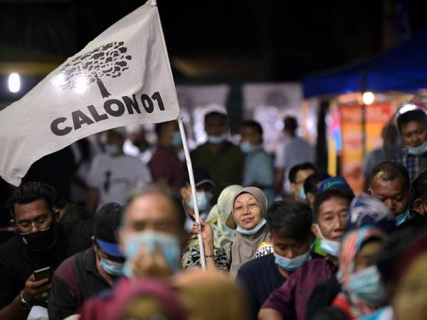 Seorang penyokong Calon Bebas Amir Khusyairi Mohamad Tanusi mengibarkan bendera calon tersebut ketika tinjauan pada program ceramah perdana sempena PRK DUN Slim hari ini. - Foto Bernama