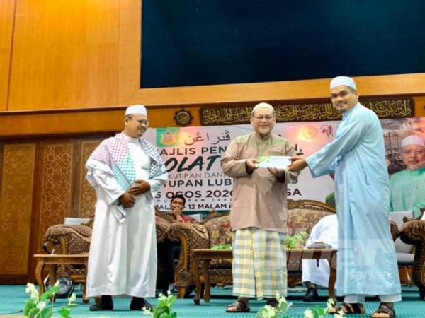 Wakil kepada Menteri Besar Kelantan, Mohd Asri Mat Daud (kanan) menyerahkan sumbangan bagi membantu mangka letupan Beirut di Lubnan kepada Mohd Amar.