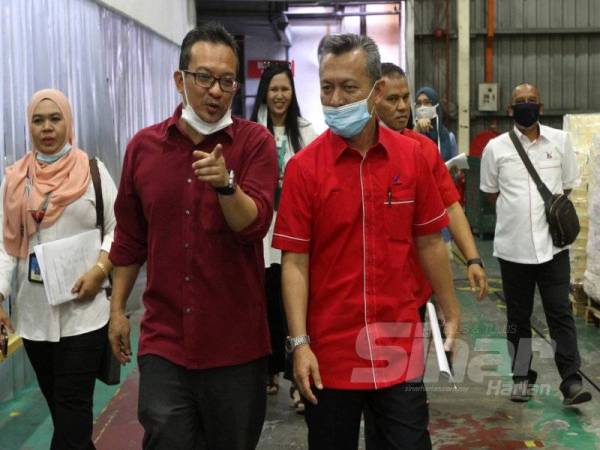 Akmal Eirfan (dua dari kiri) memberi penerangan kepada Razali ketika sesi lawatan Ketengah ke kilang percetakan milik Kumpulan Karangkraf di Shah Alam semalam.