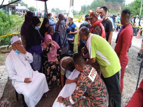 Ahli keluarga tidak dapat menahan sebak ketika melihat mayat mangsa selepas ditemui kira-kira 1.4 kilometer dari lokasi mangsa jatuh. - Foto ihsan Bomba