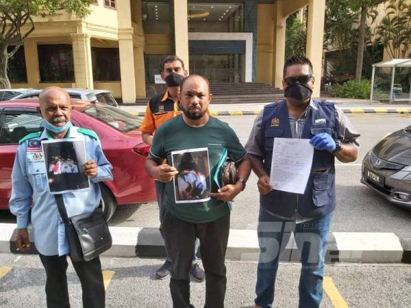 Jamil (tengah) menunjukkan gambar anaknya yang diedarkan di tempat awam bersama anggota Ikatan Rakyat Insan Muslim Malaysia (IRIMM) semalam.