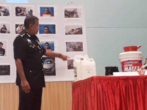 Ayob menunjukkan botol diisikan dengan cat merah yang digunakan untuk disimbah pada rumah peminjam selepas gagal melunaskan hutang pada sidang akhbar di IPK Johor, Johor Bahru hari ini.