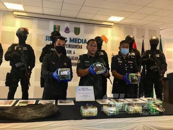 Rozasin (tengah) ketika menunjukkan dadah yang dirampas dan disembunyikan dalam plastik teh pada sidang akhbar Kem Batalion 6 PGA Bakri, Muar, Johor hari ini.