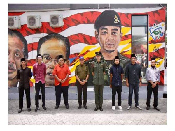 Barisan pelukis bersama Tengku Hassanal bergambar di hadapan mural yang dihasilkan mereka ketika lawatan baginda hari ini.