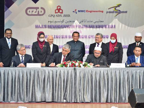 Ahmad Samsuri (berdiri, tengah) menyaksikan Majlis Menandatangani Perjanjian Pembentukan Konsortium bagi Projek ECRL di Primula Beach Hotel di sini hari ini. -Foto: UPDI