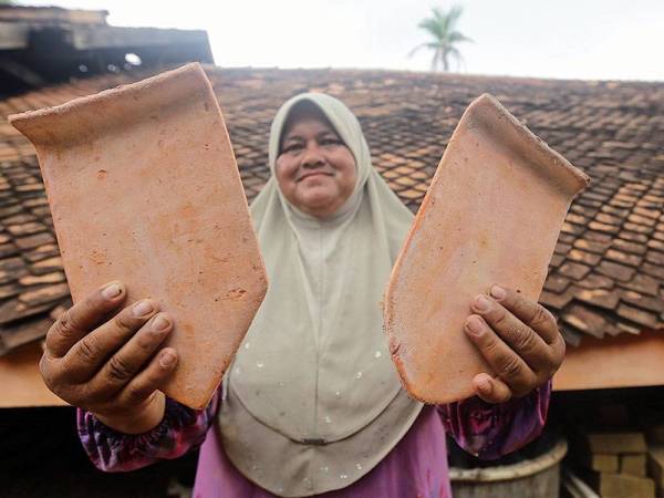 Noraini menunjukkan hasil atap yang telah siap diproses di Noraini Atap Bata Singhora, Kampung Pengkalan Baru. - Foto: Bernama