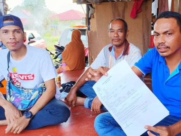 Mohd Subri (kanan) dan Johar (tengah) serta Rohaizat (kiri) menunjukkan laporan polis yang dibuat di Ibu Pejabat Polis Daerah Bachok.