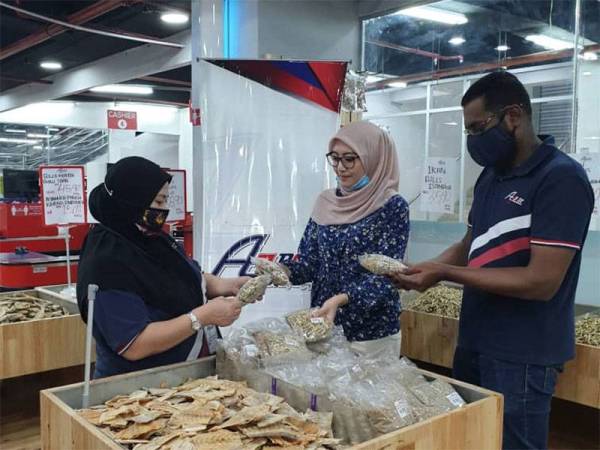 Yusra (tengah) bersama Ketua Pegawai Operasi AJ Best Holdings Sdn Bhd, Fahim Anwar Ali (kanan) dan Pengurus pasar raya AJ Best cawangan Chow Kit, Kuala Lumpur Ayu meneliti produk SR Food yang baru dibawa masuk dari Tawau, Sabah.
