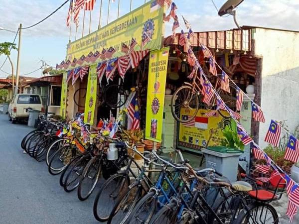 Pekarangan rumah Md Rahim yang dihiasi dengan Jalur Gemilang dan deretan basikal tua.