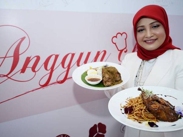 Mimie Azura menunjukkan Anggun Nasi Lemak Rendang Peanut Butter dan Asam Pedas Lamb Grill Spaghetti pada Majlis Pembukaan Restoran Anggun Chef Kafe di MITEC, Kuala Lumpur Selasa lalu.