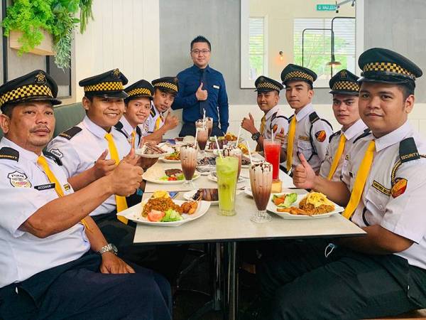 Calvin (berdiri) bersama beberapa pengawal keselamatan yang diraikan dalam jamuan penghargaan di Secret Recipe, Alamanda baru-baru ini.