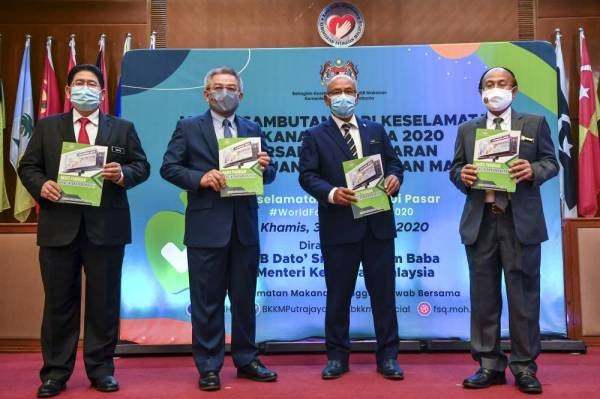 Dr Adham (dua dari kiri) menunjukkan Garis Panduan Pengiklanan Makanan pada majlis Sambutan Hari Keselamatan Makanan Sedunia di Kementerian Kesihatan, Putrajaya hari ini. - Foto Bernama
