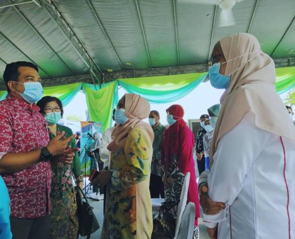 Ahmad Saidi (kiri) menyantuni pegawai kesihatan yang hadir ke Sambutan Hari Keselamatan Makanan Sedunia Peringkat Negeri Perak di Pasar Awam Batu Gajah hari ini.