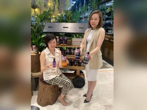 Tiffany (kanan) menunjukkan rangkaian produk penjagaan rambut KUNDAL yang kini boleh didapati di Guardian.