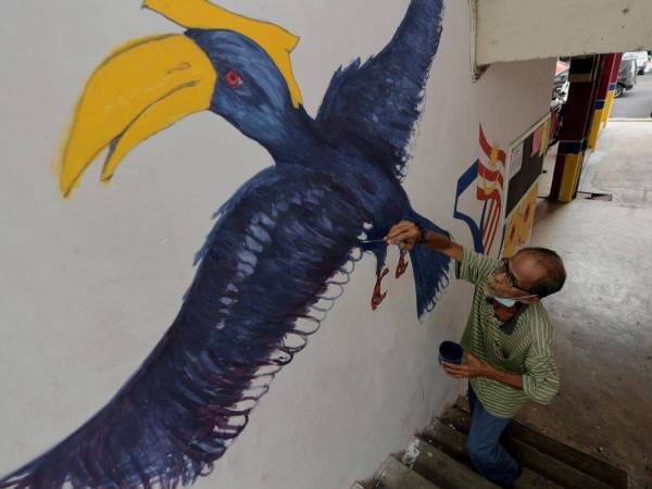 Penghuni Program Perumahan Rakyat (PPR) Taman Desa Mutiara Zulkifli Omar, 63, tekun melukis mural Burung Enggang dan Orang Hutan di Blok 11, taman perumahan itu ketika ditemui baru-baru ini.