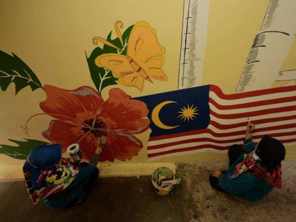 Dua ahli jawatankuasa wanita Program Perumahan Rakyat (PPR) Taman Desa Mutiara melukis Mural Jalur Gemilang dan Bunga Kebangsaan di Blok 20 taman perumahan itu ketika ditemui baru-baru ini. - Foto Bernama