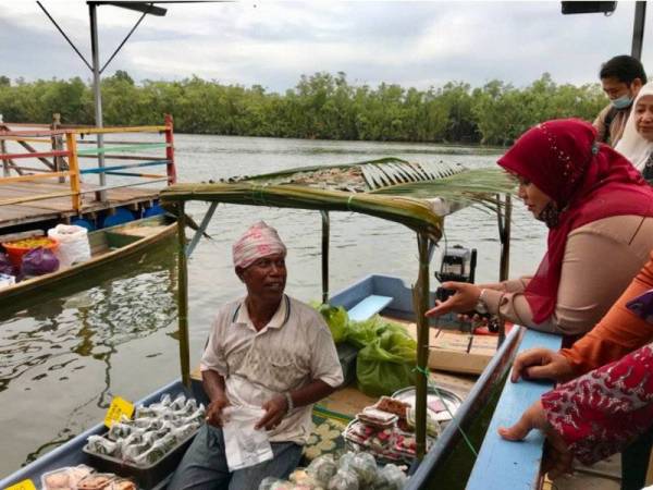 Mas Ermiyati beramah mesra bersama penjual yang berniaga di Pasar Tani Pelancongan Pengkalan Datu di pekarangan Cerana Villa Resort.