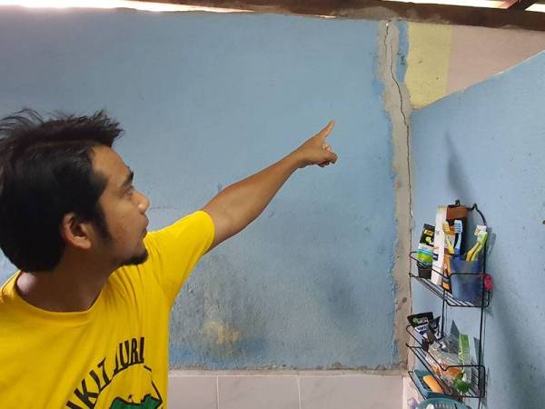 Penduduk menunjukkan keadaan rumahnya yang retak akibat impak letupan di kawasan kuari.