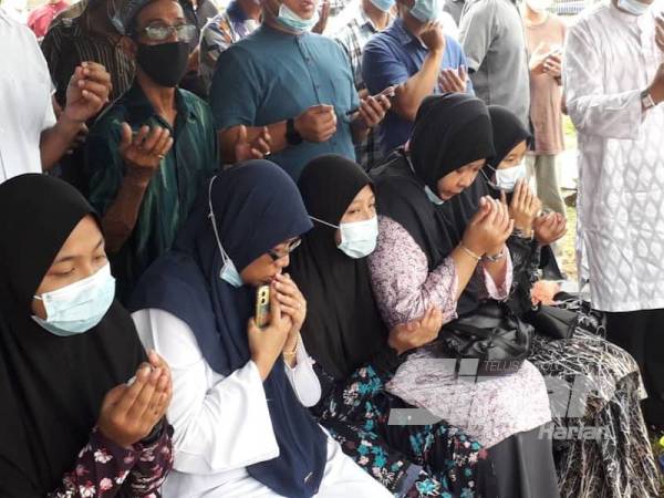 Fauzi Noraini dan anak-anaknya tidak dapat menahan sedih semasa mengaminkan doa untuk Allahyarham Mohd Fahami di Tanah Perkuburan Islam Mount Austin, Johor Bahru hari ini.