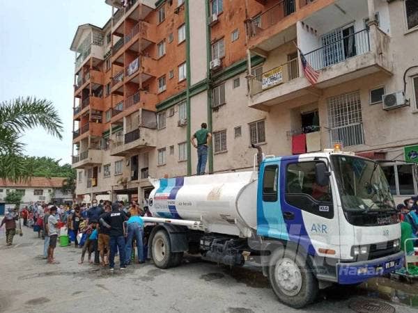 Orang ramai sedang mengambil bekalan air bersih.