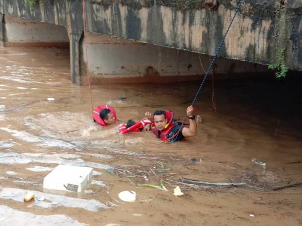Anggota bomba menyelamatkan seorang kanak- kanak lelaki yang berpaut pada tembok di bawah jambatan dekat Persiaran Seri Alam, petang tadi.