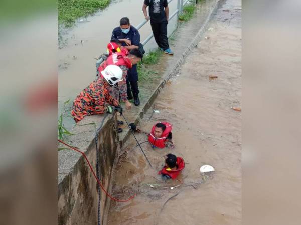 Anggota bomba menyelamatkan Zul Rosaidi yang berpaut pada tembok di bawah jambatan dekat Persiaran Seri Alam, petang tadi.