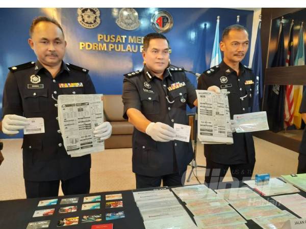 Mohd Rosni (tengah) bersama pegawainya menunjukkan barangan yang dirampas dari suspek.