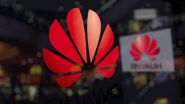 Huawei logo on the glass against blurred business center. Editorial 3D