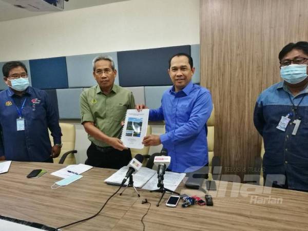 Abdul Yunus (kanan) menerima kertas cadangan Projek Perikanan Bandar daripada Zaki ketika sidang akhbar di Bangunan Perak Darul Ridzuan di sini hari ini.