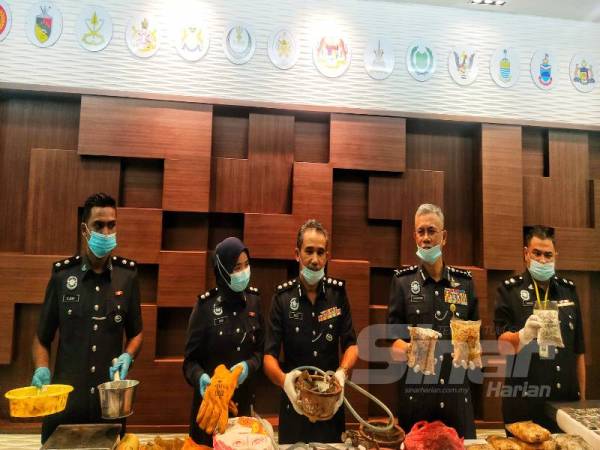 
Hasanuddin (dua dari kanan) menunjukkan sebahagian dadah dirampas dalam serbuan di kawasan ladang kelapa sawit Sungai Division, Sungai Petani Isnin lepas.