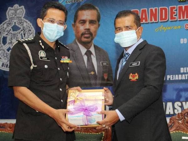 Adnan (kanan) menyampaikan sijil penghargaan kepada ketua-ketua jabatan yang bertugas di negeri ini sepanjang PKP menentang pandemik Covid-19.
