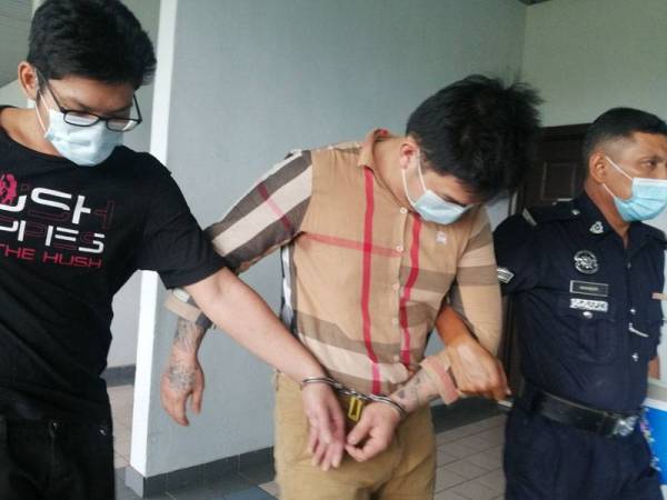 Fook Jing (dua dari kanan) dan Alen (kiri) dihadapkan Mahkamah Sesyen di Melaka hari ini.