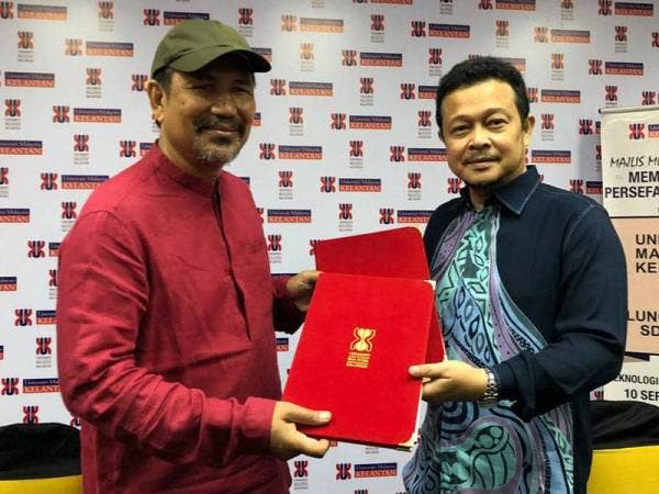 Noor Azizi (kanan) dan M Nasir bertukar perjanjian yang dimeterai antara UMK dan Luncai Emas selama lima tahun bagi pembangunan seni serta warisan.