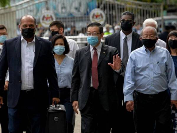 Lim Guan Eng diiringi peguamnya Gobind Singh Deo (kiri) dan RSN Rayer tiba di Mahkamah Sesyen Butterworth hari ini. - Foto Bernama