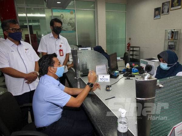 Mohd Shahar (duduk) beramah mesra dengan kakitangan KWSP di Seremban.