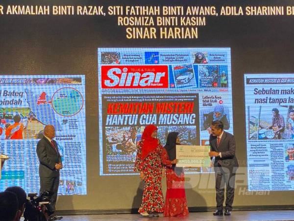 Mohd Radzi Md Jidin menyampaikan hadiah kepada wartawan Sinar Harian yang memenangi kategori Laporan Berita Cemerlang.