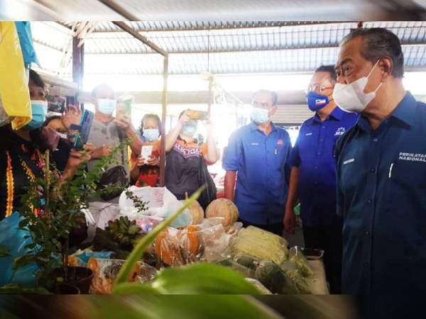Muhyiddin ketika lawatannya ke Pasar Am Tuaran hari ini sempat bertemu peniaga, Nancy Misun dan bertanya sayur yang dijualnya.