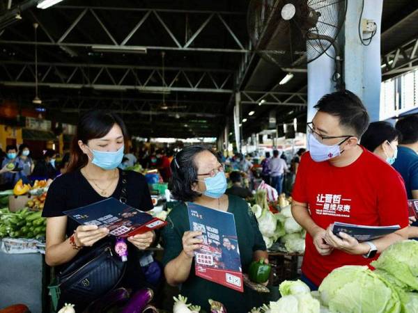 Ginger Phoong menyerahkan risalah kempen kepada pengunjung Pasar Lido Kota Kinabalu pagi ini.