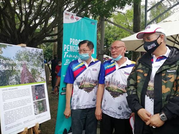 Annuar (kanan) meninjau pelan gerak kerja pengindahan Taman Awam Bukit Kiara di Kuala Lumpur hari ini.
